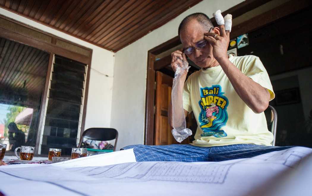 Marianto memeriksa peta konsesi sawit di rumahnya di Kuala Pembuang